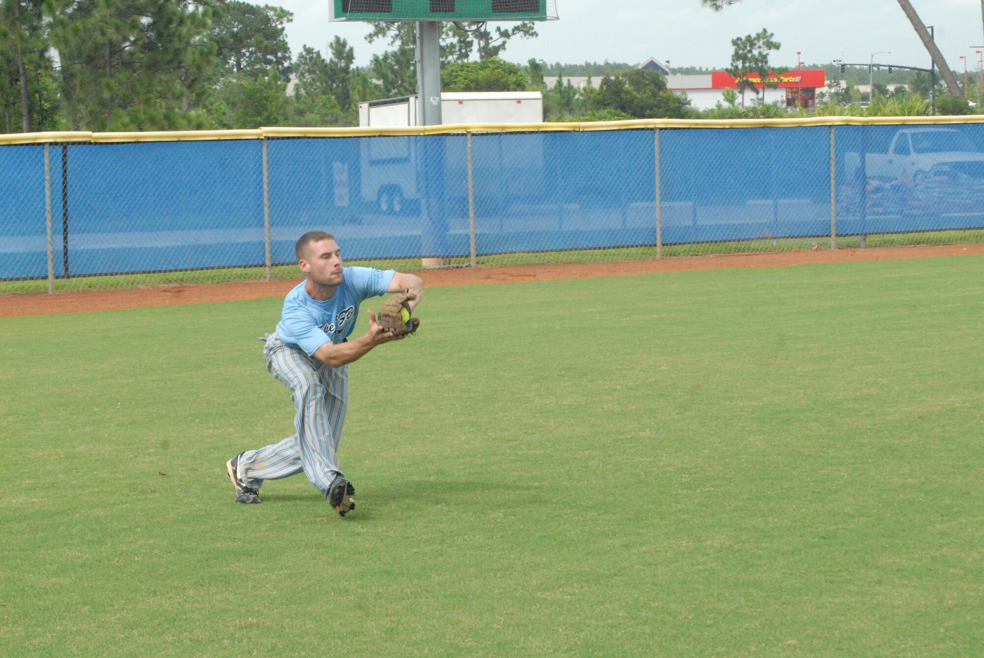 Senior Airman Greg Taylor, 43rd Security Forces Squadron and member of the Pope Air Force Base All-Star Softball Team, makes a catch in left field against Patrick Air Force Base, Fla. team August 16 at the Military Softball World Series in Kissimmee, Fla. (U.S. Air Force Photo by 2nd Lt. Chris Hoyler)