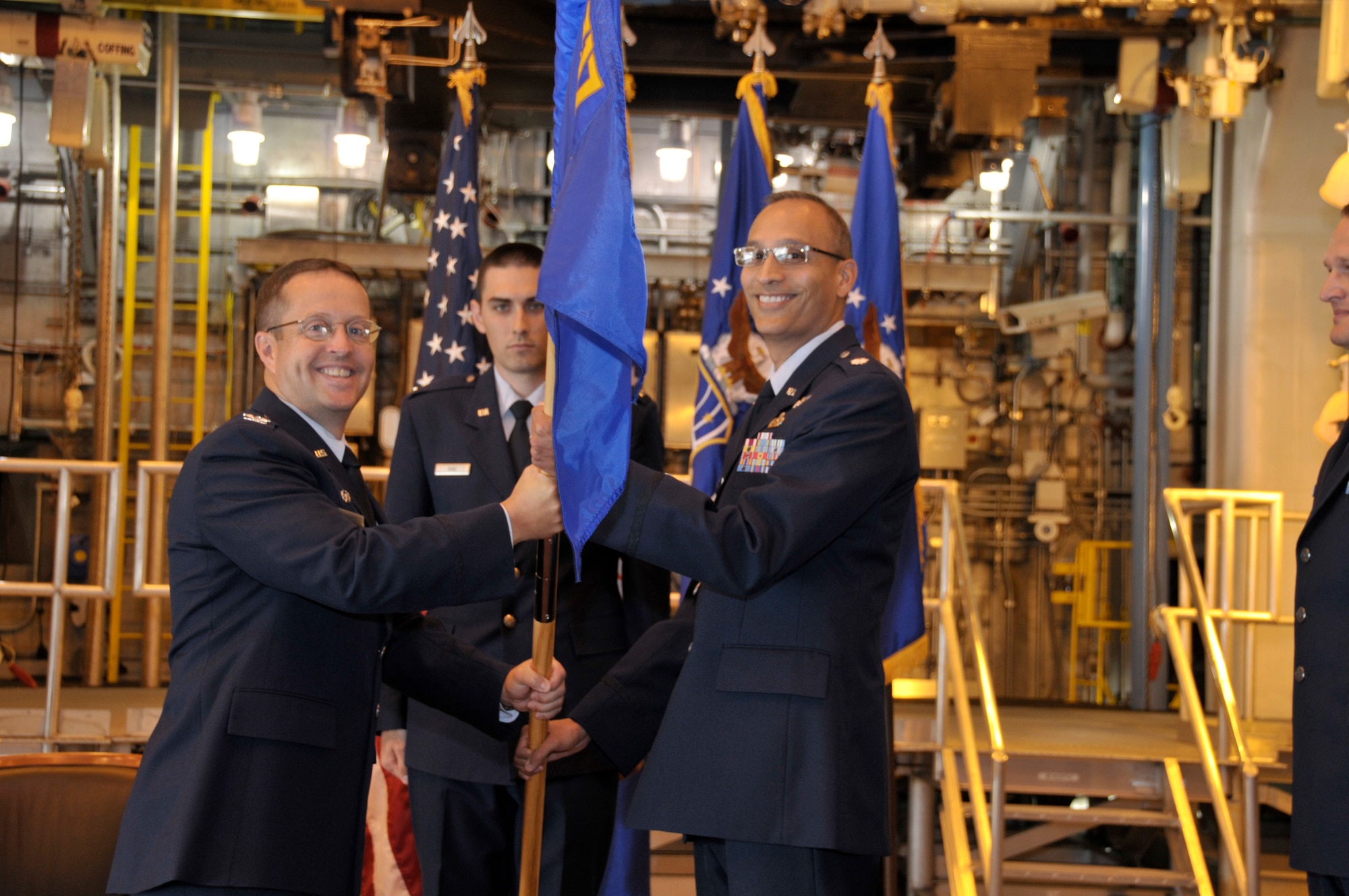Commander of Arnold Engineering Development Center’s 704th Test Group Col. James Jolliffe hands the 717th Test Squadron flag to new squadron commander Lt. Col. Najeeb Ahmed. (Photo by Rick Goodfriend)