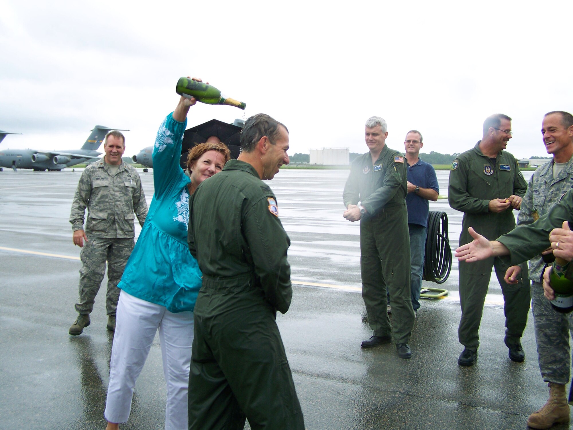 315th Airlift Wing Vice Commander Colonel Mark Bauknight's wife Leslie congratulates him with a champagne shower after being "welcomed" back from his final flight.  Col. Bauknight will retire this Sunday after spending 23 years in the Air Force. (U.S. Air Force photo/ Capt. Wayne Capps)