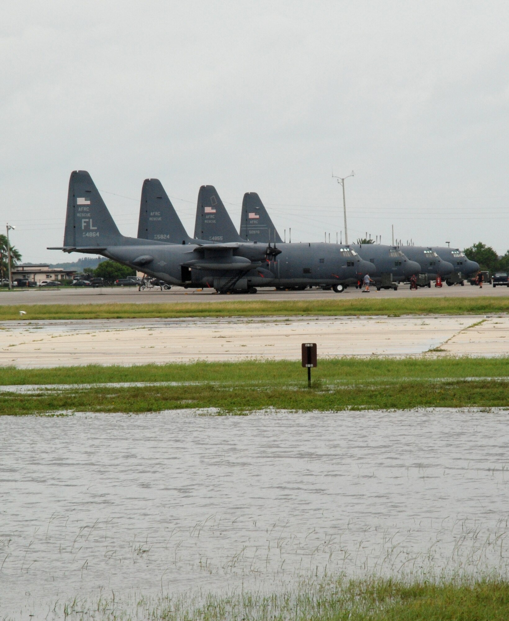 PATRICK AIR FORCE BASE, Fla. - Airmen from the 920th Rescue Wing here reported for duty Friday, Aug. 22 after being directed to shelter at home most of the week while Tropical Storm Fay drenched the base and surrounding area with record-breaking rainfalls.  Weather officials from Cape Canaveral Air Force Station said Patrick  AFB received an off-the-charts 23.81 inches of rain.  Rescue wing Airmen were affected in more ways than one because in addition to their military positions as Air Force Reservists here, they hold regular civilian jobs and live in and around the local community.  At one point during the week, the storm stalled overhead causing flooding which delaying approximately 70 Air Force Reservists who were scheduled to deploy to Afghanistan Thursday. Standing water remains in many areas throughout the base especially around the tarmac as rescue wing maintainers unmoored the HC-130P/N Hercules aircraft Friday morning to prepare them for their missions. (U.S. Air Force Photo/Capt. Cathleen Snow)