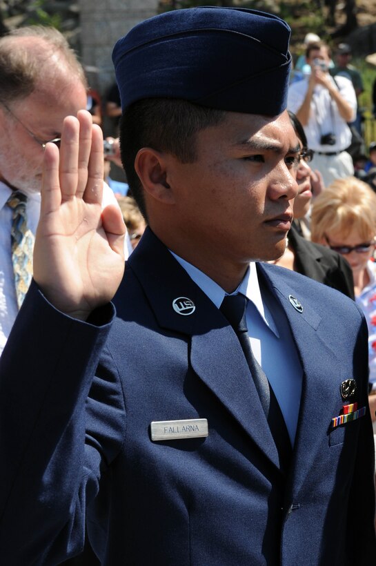 Airman 1st Class Ronald Fallarna, Air Force Financial Services Center military pay technician, raises his right hand during a naturalization ceremony at Mount Rushmore National Memorial, S.D., Aug. 21.  Airman Fallarna is one of five Airmen from Ellsworth who is taking his last step to become an American citizen. (U.S. Air Force photo/Airman 1st Class Adam Grant) 


