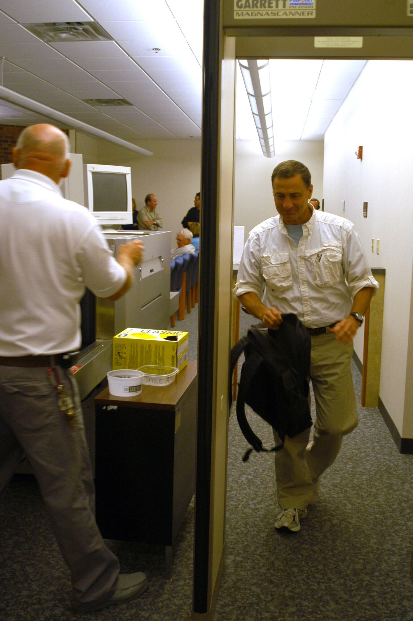 GRISSOM AIR RESERVE BASE, Ind.,  -- Rick Hawks prepares to enter the passenger screening scanner as Morris Bromfield, air traffic assistant with Data Monitoring Systems, Inc. Mr. Hawks participated in an aerial refueling mission here Aug. 20 with 27 other civic leaders from Fort Wayne and Indianapolis.