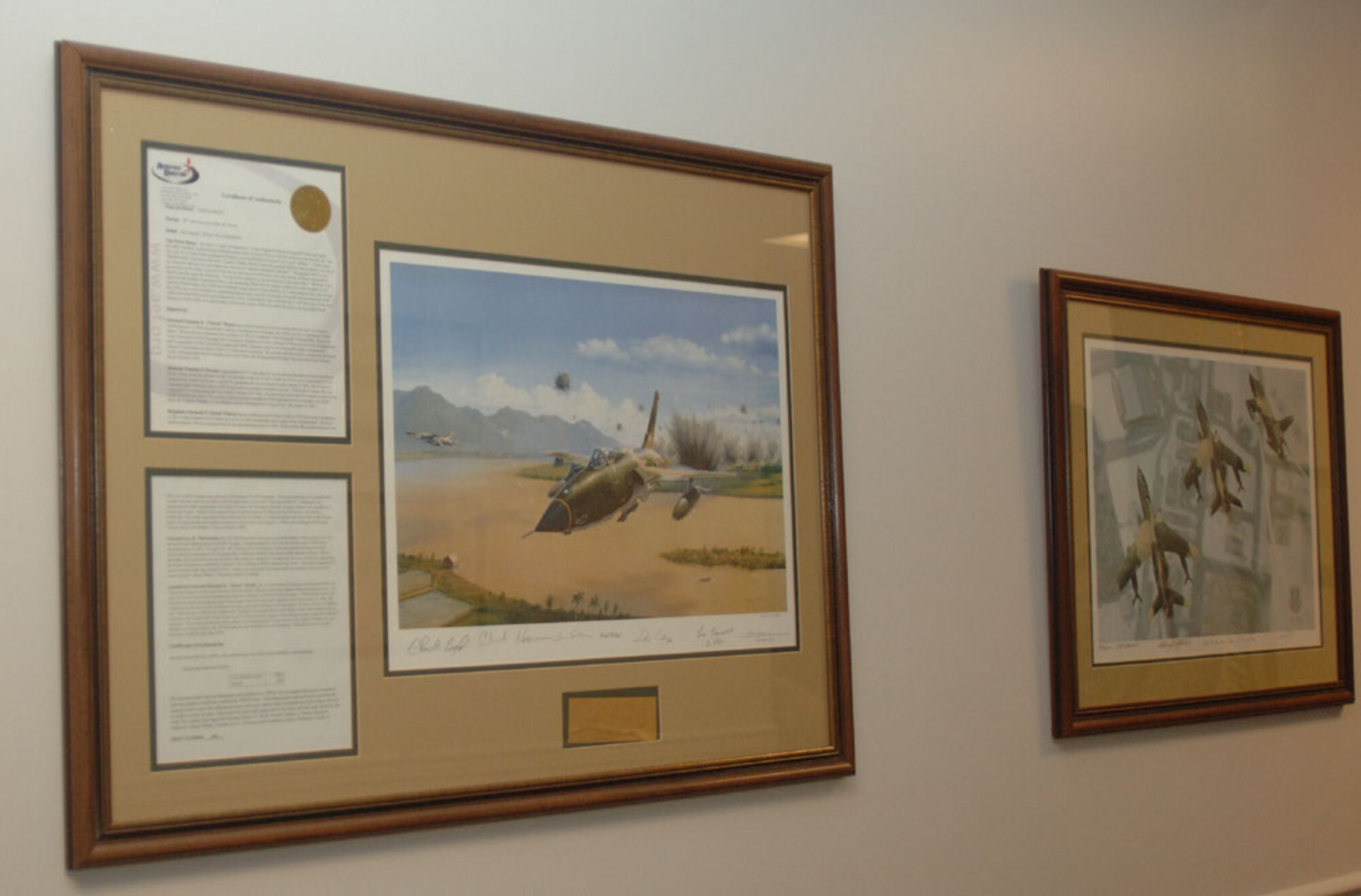 The artwork "Thud Ridge" portrays the F-105D in the first official attack of the Vietnam War. This print is signed by past members of the 50th Flying Training Squadron to include Lt. Col. Richard "Gene" Smith, Jr. of which the plaza at Columbus AFB is named after. (U.S. Air Force photo by Senior Airman Danielle Hill)