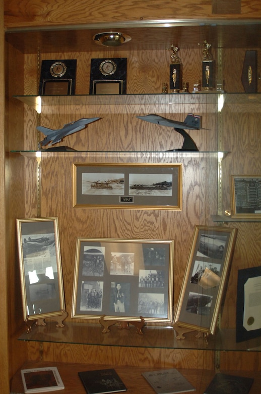 One of the many displays throughout the hallways of the 50th Flying Training Squadron containing pictures of old squadron members and trophies won. Lt. Col. Youngsworth is depicted in the picture frame directly beneath the air craft models. These pictures are part of the Youngsworth collection. (U.S. Air Force photo by Senior Airman Danielle Hill)
