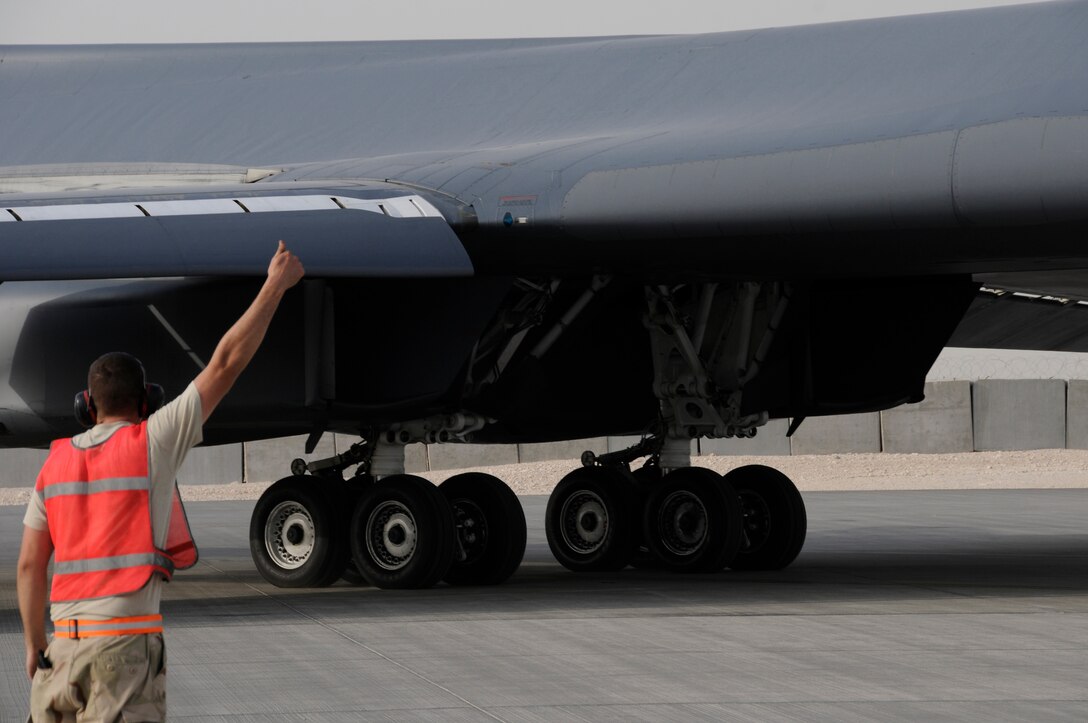 Senior Airman Reilly White, a crew chief assigned to the 379th Expeditionary Aircraft Maintenance Squadron, 34th Aircraft Maintenance Unit, marshals a B-1 Lancer from its parking spot Aug. 21, 2008, at an undisclosed air base in Southwest Asia.  Prior to flight, crew chiefs inspect and perform various functional checks of the aircraft as well as ensure that the aircraft has been properly serviced with fuel, hydraulic fluid and liquid oxygen.  B-1s assigned to the 379th are regularly called upon for precision air strikes in support of Operations Iraqi Freedom and Enduring Freedom.  Airman White, a native of Williamsport, Pa., is deployed from Ellsworth Air Force Base, S.D. (U.S. Air Force photo by Tech. Sgt. Michael Boquette/Released)