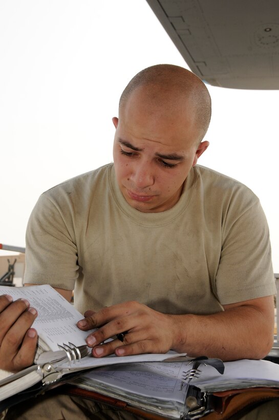 Staff Sgt. Vincent Avila, 379th Aircraft Maintenance Squadron, 34th Aircraft Munitions Unit, checks technical orders for correct T.O. numbers for the maintenance he performed on a B-1 Aug. 21, 2008.  Sergeant Avila, an electrical and environmental system specialist, must track each task completed and any parts added or removed from the aircraft in the aircraft's maintenance log.  Sergeant Avila, a native of Santa Barbara, Calif., is deployed to an undisclosed air base from Ellsworth Air Force Base, S.D., in support of Operations Iraqi Freedom, Enduring Freedom and Joint Task Force-Horn of Africa. (U.S. Air Force photo by Tech. Sgt. Michael Boquette/Released)