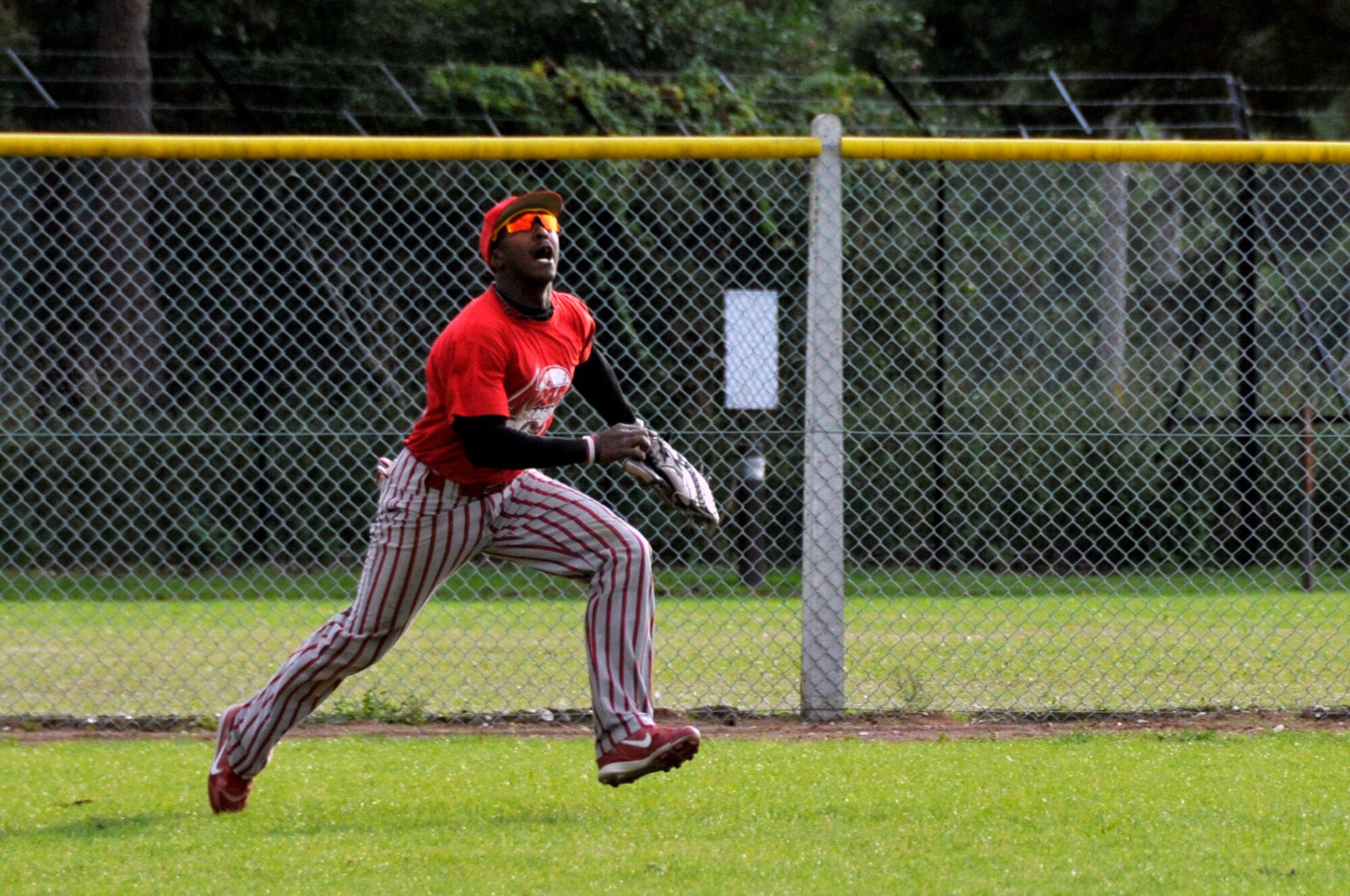 An outfielder for the Aviano Dragons sprints for a fly ball Aug. 16 at RAF Lakenheath, England. The Dragons beat the Spandahlem Sabers 23 - 11 to take the USAFE Softball Chapmionship title. (U.S. Air Force photo by Airman Perry Aston) 