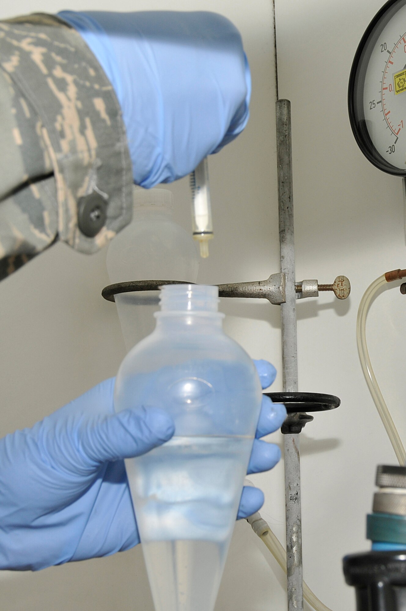 Senior Airman Matthew Young, 48th Logistics Readiness Squadron, fuel lab technician adds water to a sample of fuel Aug. 12 at RAF Lakenheath, England. The lab tests fuel three separate times to ensure the chemicals in the fuel are able to trap any moisture and separate it from the fuel.  (U.S. Air Force photo by Airman Perry Aston) 