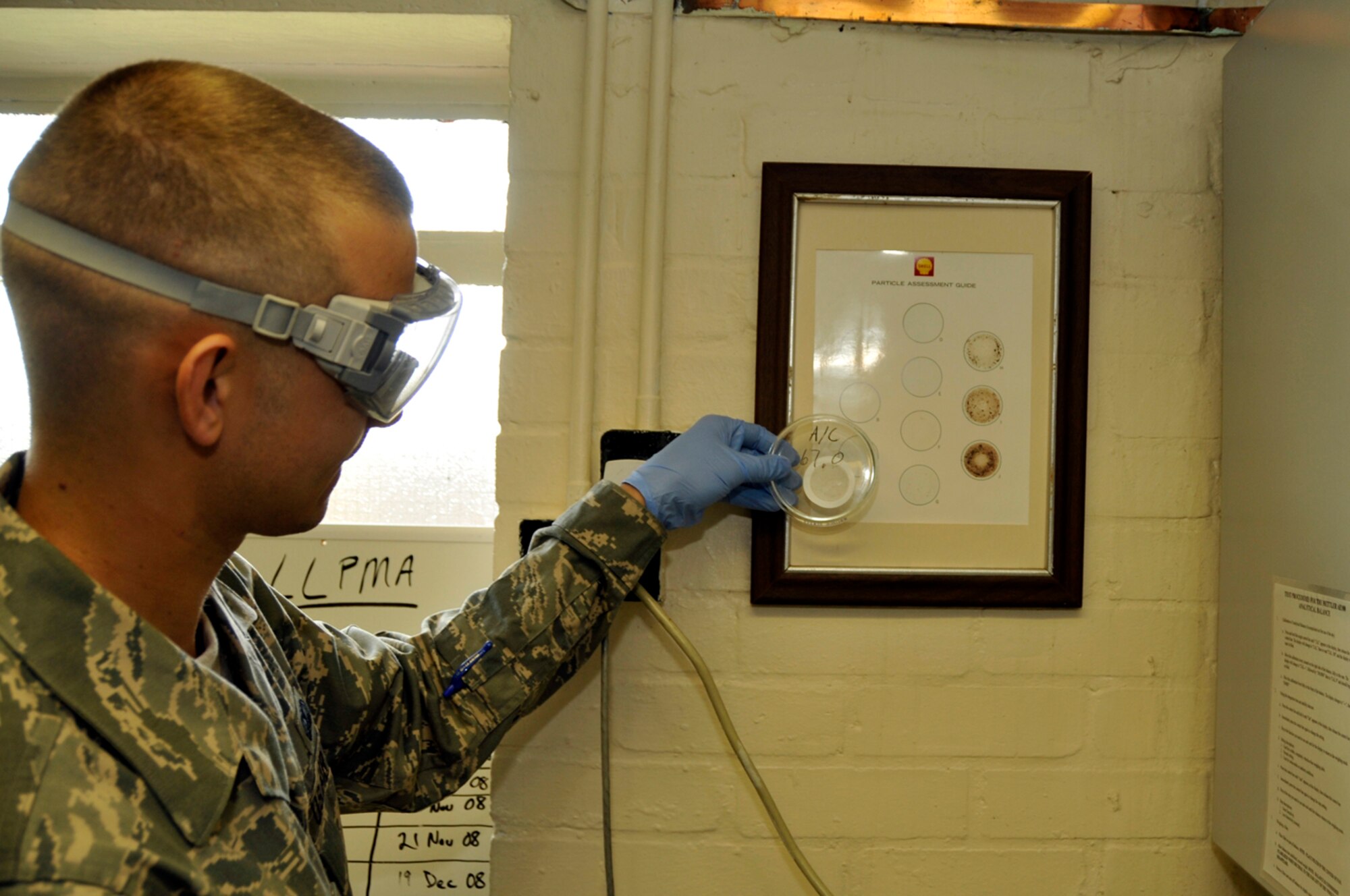 Senior Airman Matthew Young, 48th Logistics Readiness Squadron, fuel lab technician compares a filter sample to a guide Aug. 12 at RAF Lakenheath, England. If there is too much sediment in then fuel it could damage the engines. (U.S. Air Force photo by Airman Perry Aston) 