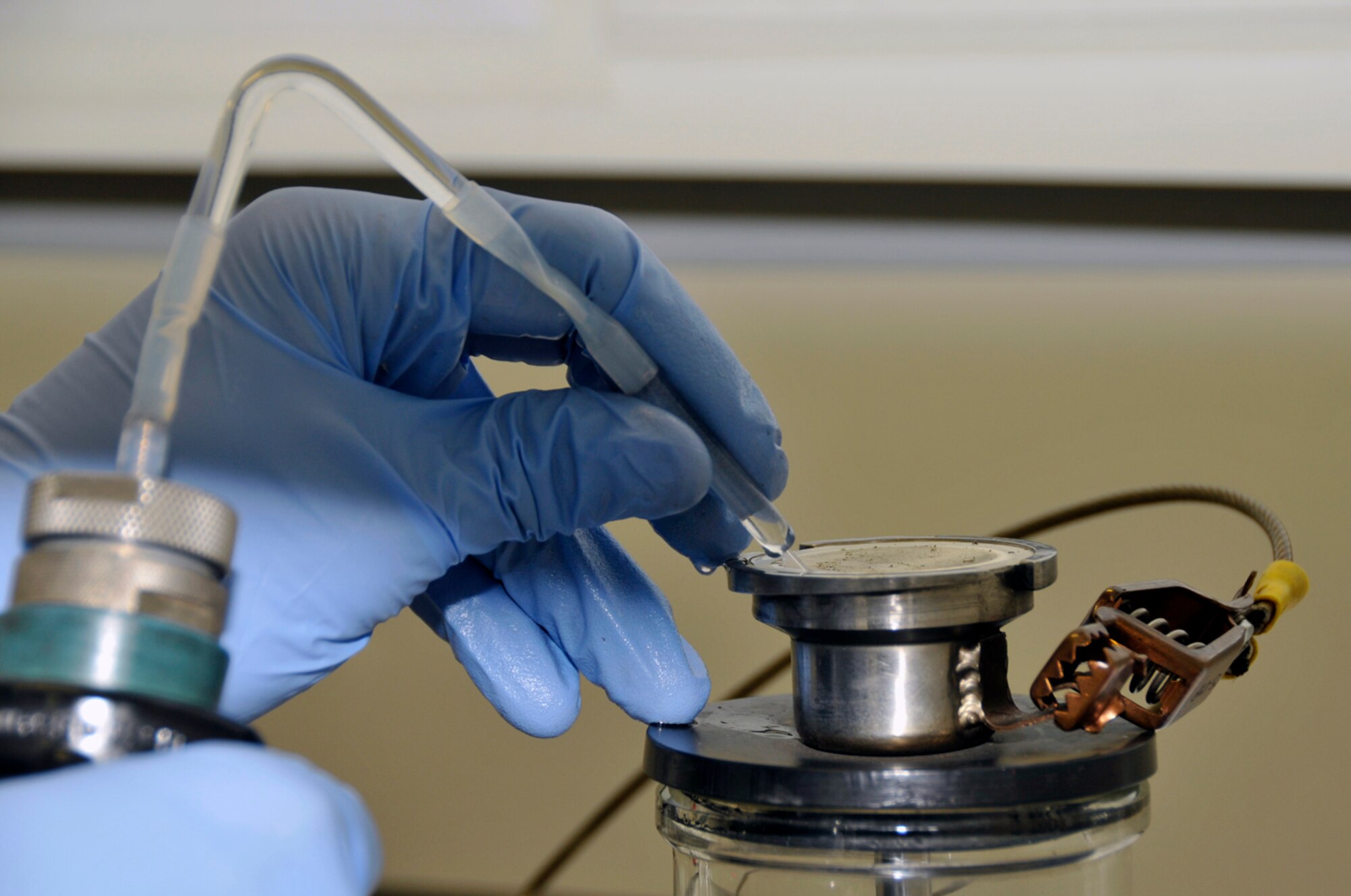 Senior Airman Matthew Young, 48th Logistics Readiness Squadron, fuel lab technician squirts filtered ether over the filter Aug. 12 at RAF Lakenheath, England. Airman Young must make sure all the sediment is in the filter so he can properly inspect it. (U.S. Air Force photo by Airman Perry Aston) 