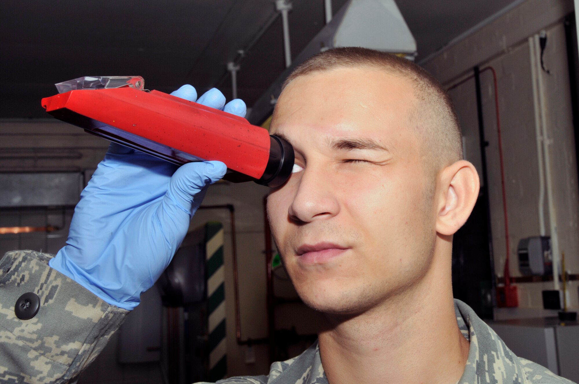 Senior Airman Matthew Young, 48th Logistics Readiness Squadron, fuel lab technician looks through a refractor Aug. 12 at RAF Lakenheath, England. The refractor is used to test how much water is present in the fuel. (U.S. Air Force photo by Airman Perry Aston) 