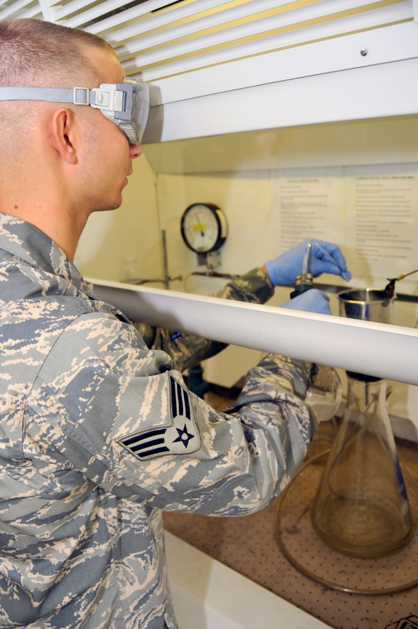 Senior Airman Matthew Young, 48th Logistics Readiness Squadron, fuel lab technician pours fuel through a filter to catch any foriegn particals Aug. 12 at RAF Lakenheath, England. Fuel must be tested when it comes onto the base, before it goes into the storage tanks and while it is in the storage tanks. (U.S. Air Force photo by Airman Perry Aston) 