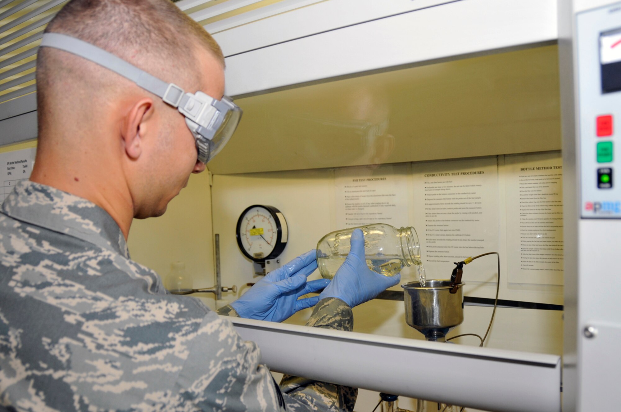 Senior Airman Matthew Young, 48th Logistics Readiness Squadron, fuel lLab technician pours fuel through a filter to catch any foriegn particals Aug. 12 at RAF Lakenheath, England. Fuel must be tested when it comes onto the base, before it goes into the storage tanks and while it is in the storage tanks. (U.S. Air Force photo by Airman Perry Aston) (Released)