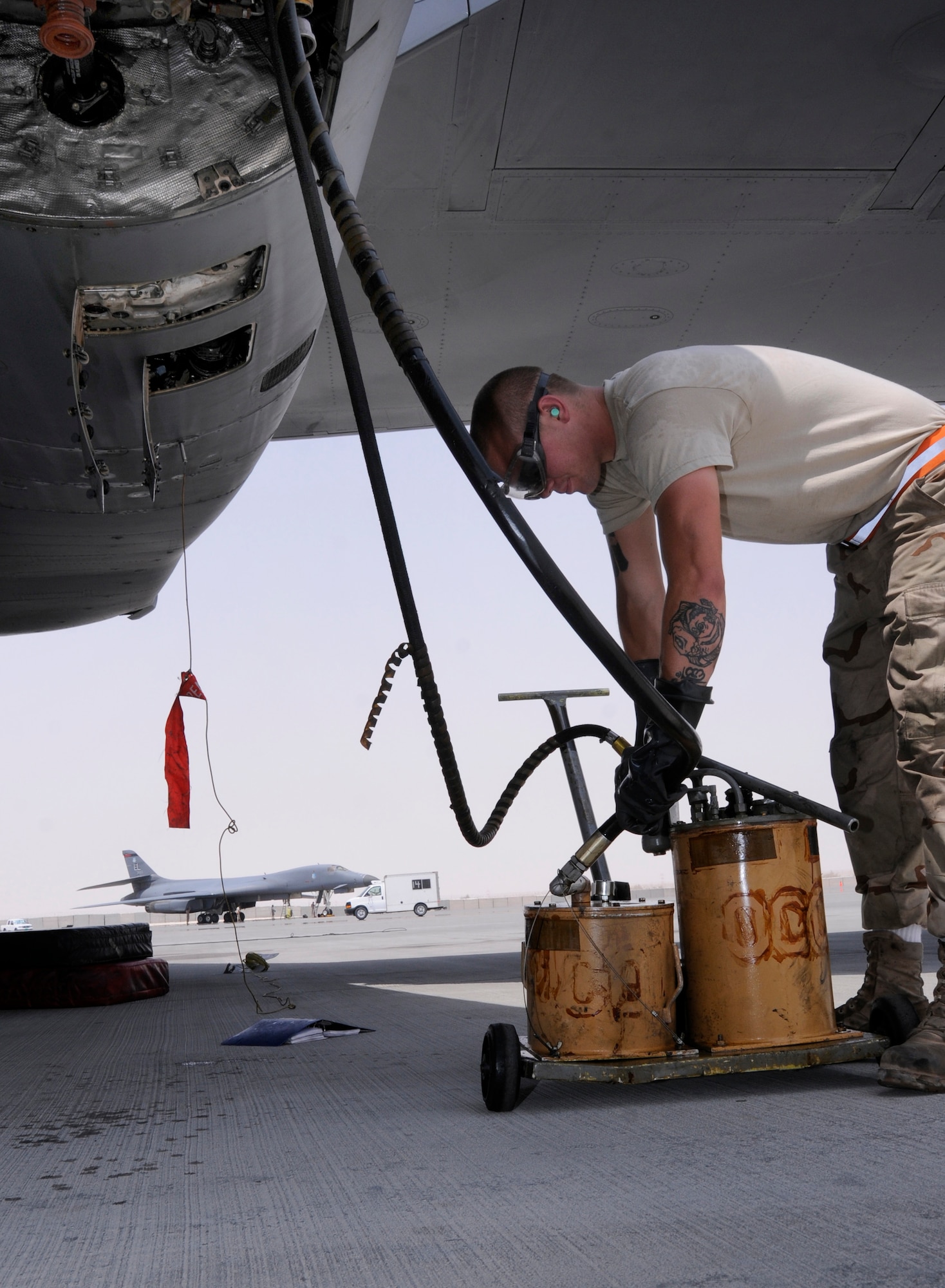 Airman 1st Class Doug Robertson, 379th Expeditionary Aircraft Maintenance Squadron, 34th Aircraft Maintenance Unit, pumps engine oil into the B-1 Lancer topping off the engine oil as part of a post-flight inspection Aug. 20, 2008.  The topping off of the oil is part of a normal post flight inspection performed by a team of maintainers after each flight.  Airman Robertson, a native of Sanford, N.C., is deployed from Ellsworth Air Force Base, S.D., in support of Operations Iraqi Freedom, Enduring Freedom and Joint Task Force-Horn of Africa. (U.S. Air Force photo by Tech. Sgt. Michael Boquette/Released)