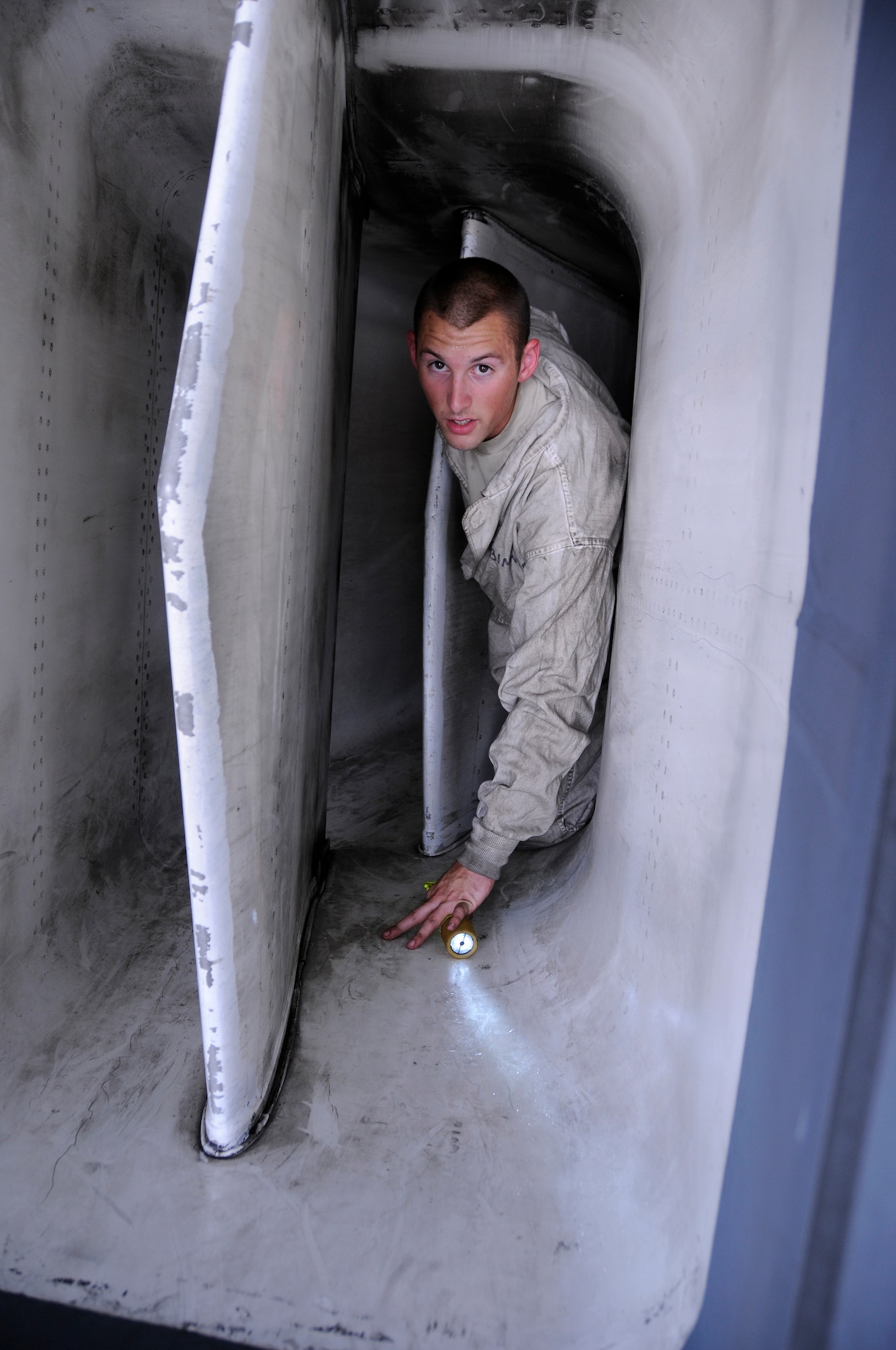 Senior Airman Brandon Scott, 379th Expeditionary Aircraft Maintenance Squadron, 34th Aircraft Maintenance Unit, crawls to daylight after performing an inlet exhaust inspection on a B-1 Lancer aircraft Aug. 20, 2008.  The inspection is part of a normal post-flight inspection performed by a team of maintainers after each flight.  Airman Scott hails from Charlotte, N.C., and is deployed from Ellsworth Air Force Base, S.D., in support of Operations Iraqi Freedom, Enduring Freedom and Joint Task Force-Horn of Africa. (U.S. Air Force photo by Tech. Sgt. Michael Boquette/Released)