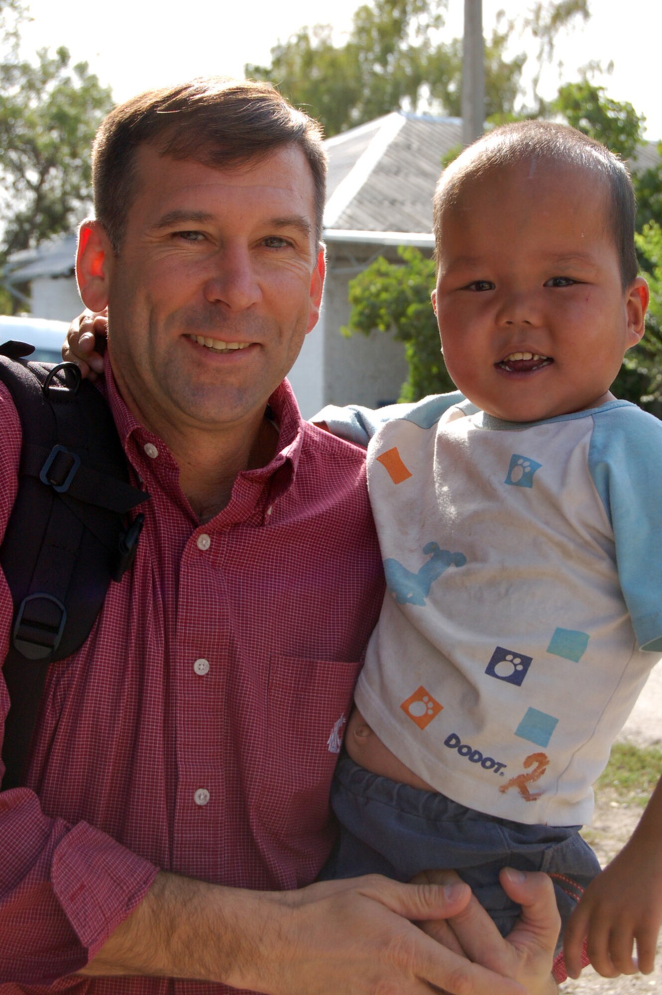 08/14/2008 - MANAS AIR BASE, KYRGYZ REPUBLIC -- Col. Christopher Bence, 376th Air Expeditionary Wing commander enjoys a happy moment with a young Kyrgyz boy during a concert at the Belovidosky Orphanage.   The U.S. Air Forces Central band "Sirocco" was on a nine day tour at Manas AB where they played at various schools, villages and orphanages as well as the U.S. Embassy and on base. (Air Force photo / Senior Master Sgt. Patrick J. McCracken)