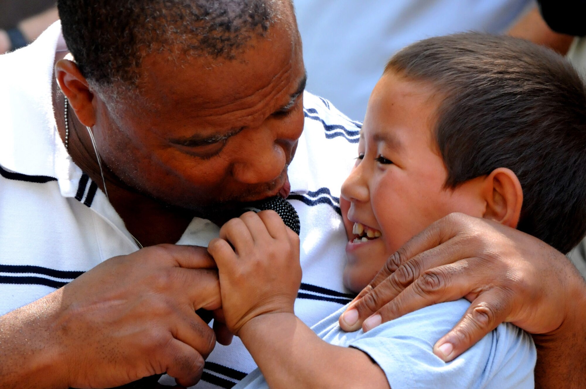 08/14/2008 - MANAS AIR BASE, KYRGYZ REPUBLIC -- Staff Sgt. Reginald Coleman, 572nd Air Force Band vocalist, belts out a tune with some help from the audience during a concert at Tok Mok II, a local Kyrgyz orphanage, Aug. 14. Throughout their ten day tour, the Sirocco band performed 15 concerts; six for Air Force personnel and seven in the surrounding communities. (Air Force photo / Airman 1st Class Ruth Holcomb)