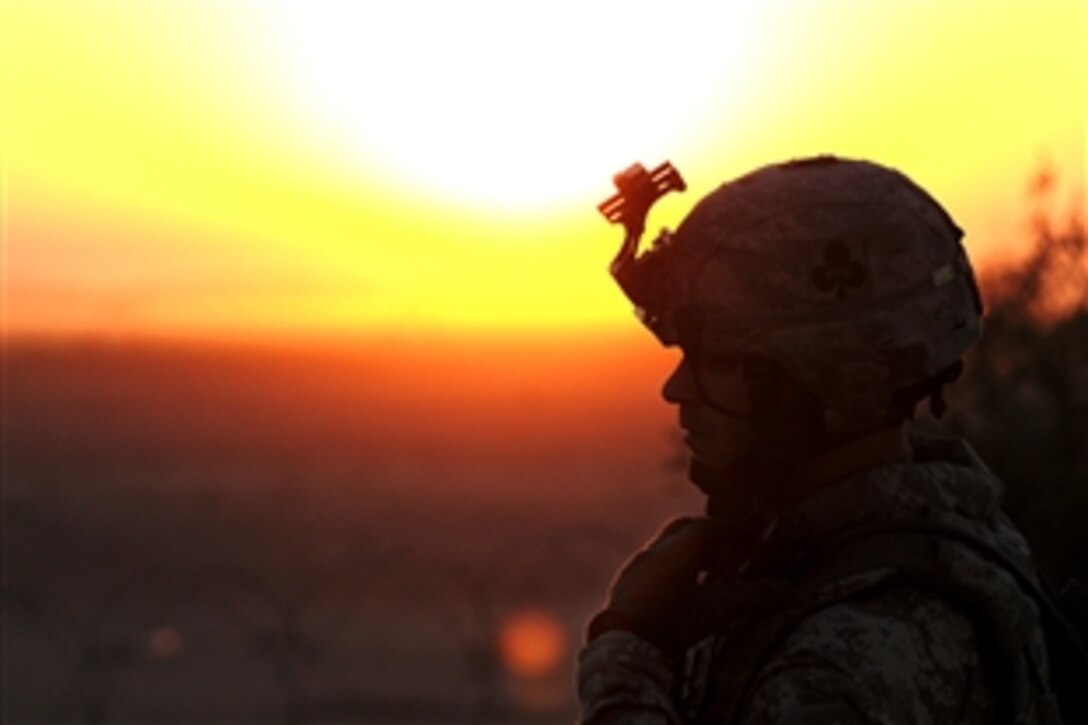 As the sun rises, U.S. Army 1st Lt. Brian Christ listens to his radio as other members of his unit move to known safe houses of al-Qaida during Operation Cretan in the Salah ad Din province, Iraq, Aug. 8, 2008. The soldiers are assigned to the 101st Airborne Division's 1st Special Troops Battalion, which conducted a combined air assault with Iraqi police. 