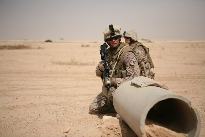 Staff Sgt. Manuel Delarosa, platoon guide and support stick leader for 1st Platoon, Company A, 4th Assault Amphibious Battalion, Multi-National Force - West, surveys his Marines Aug. 22 as they conduct quick reaction force training on Al Asad Air Base, Iraq.  The reserve Marine unit, headquartered in Norfolk, Va., is responsible for performing QRF duties for MNF-W.  Most of the Marines are trained as assault amphibious vehicle crewmen, but though their mission in Iraq has kept them from the oceans or their AAVs, they have adapted quickly to their current mission.