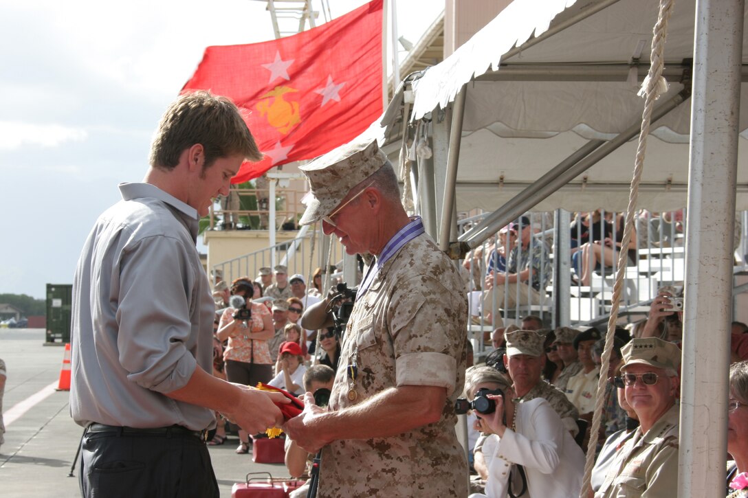 Michael Goodman (left) passes a three-star flag to his father, Lt. Gen. John F. Goodman at the flightline here Aug 22.  Goodman relinquished command of U.S. Marine Corps Forces, Pacific and retired after 41 years of military service.