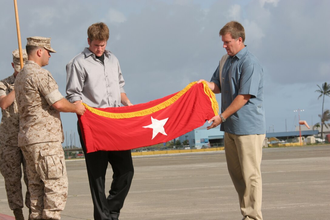 (From left to right) Capt. Jeff Goodman, Michael Goodman and John Goodman II, sons of Lt. Gen. John F. Goodman, commander, U.S. Marine Corps Forces, Pacific, fold their father's three-star flag during the MarForPac change of command and reitirement ceremony.  Their father also retired after 41 years of military service.