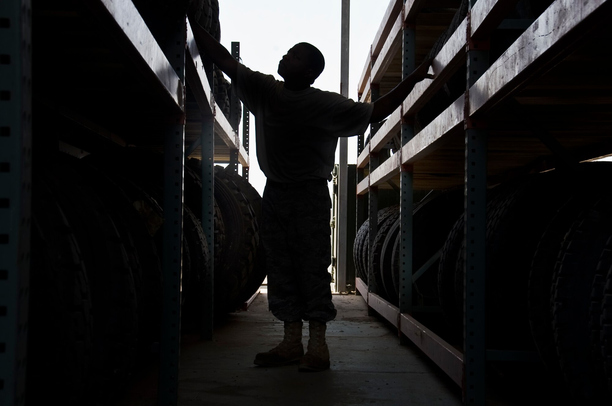 ALI BASE, Iraq -- Airman 1st Class David Beasley, 407th Expeditionary Logistics Readiness Squadron vehicle maintenance apprentice, looks for a replacement tire Aug. 22, 2008. The 10-ton roll back wrecker, used by 407th ELRS Vehicle Operations to recover small and medium broken down vehicles, had worn down tires replaced so it remains in working condition and is ready at a moment's notice. Airman Beasley is deployed from Royal Air Force Mildenhall, England. (U.S. Air Force photo/Airman 1st Class Christopher Griffin)