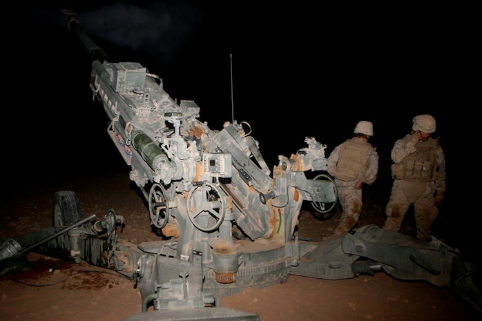 Lance Cpl. Terry A. Mastin, a food service specialist with Mike Battery, 3rd Battalion, 14th Marine Regiment, 2nd Light Armored Reconnaissance Battalion, Regimental Combat Team 5, pulls the lanyard to fire the M-777 Howitzer while Cpl. Andrew C. Ollenberger, a cannoneer with Mike Battery, looks on during an illumination shoot at Patrol Base El Dorado, Iraq, Aug. 23. The unit has been able to fire their Howitzers more than 20 times this deployment to provide illumination during night operations. Mike Battery is a reserve artillery battery based out of Chattanooga, Tenn., and attached to 2nd LAR Bn.::r::::n::