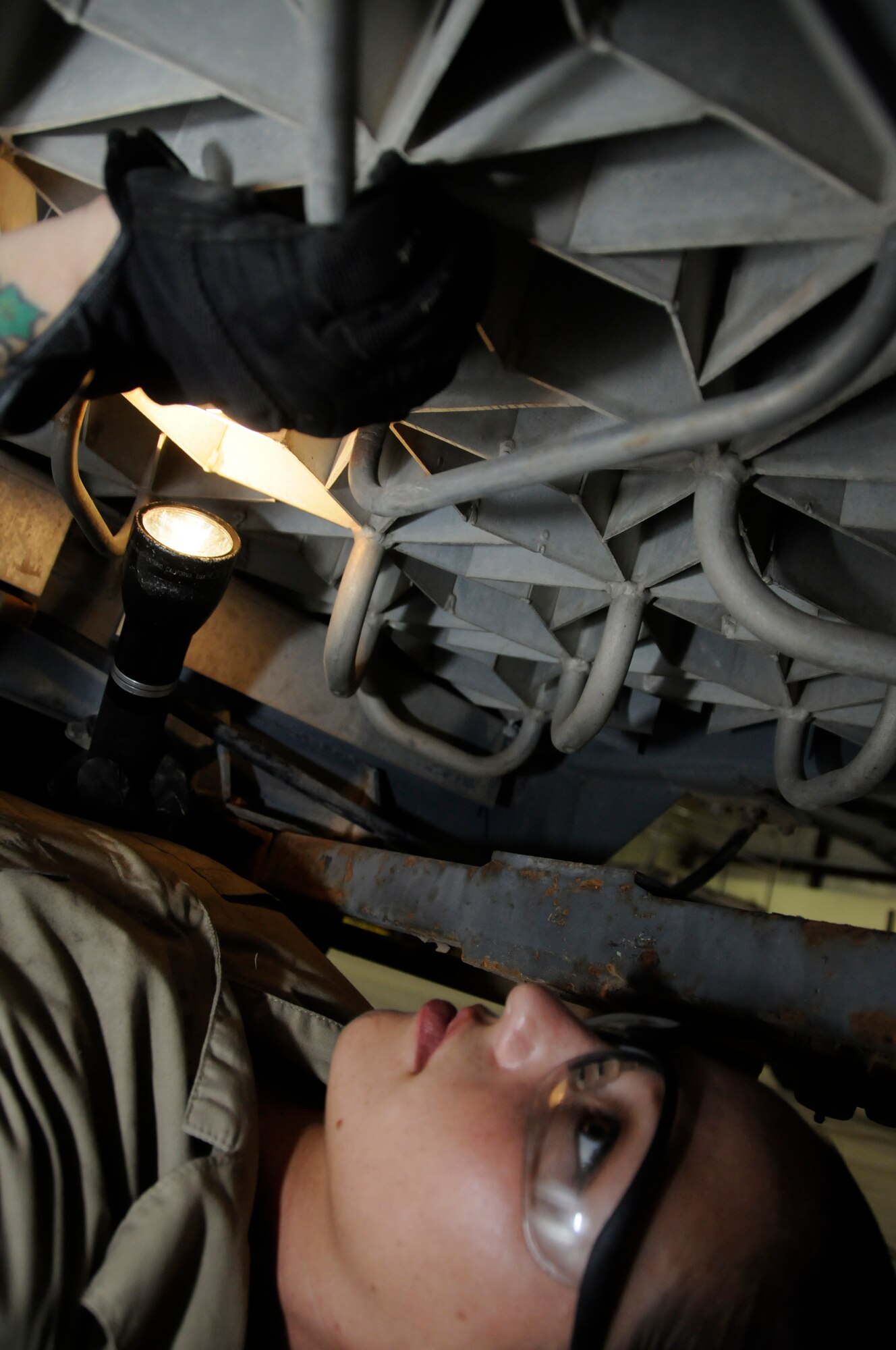 Staff Sgt. Elaina Bagnato, aerospace ground equipment (AGE) maintainer assigned to the 379th Expeditionary Maintenance Squadron, uses a flashlight to check for cracks under a liquid nitrogen cart Aug. 23, 2008, at an undisclosed air base in Southwest Asia. Sergeant Bagneto is responsible for maintaining equipment required to support Air Force aircraft while on the tarmac. Sergeant Bagneto, a native of Ventura, Calif., is deployed from Grand Forks Air Force Base, N.D., in support of Operations Iraqi Freedom, Enduring Freedom and Joint Task Force-Horn of Africa. (U.S. Air Force photo by Staff Sgt. Darnell T. Cannady/Released)