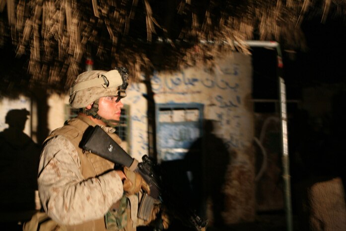 Private First Class Joe N. Viruet, a field radio operator with Jump Platoon, 3rd Battalion, 4th Marine Regiment, Regimental Combat Team 5, provides security during an operation in Hit, Iraq, Aug. 21. Marines with Jump Platoon have been performing combat patrols through Hit to assist the battalionâ??s law enforcement professional.  The platoon has been conducting the missions when they are not escorting the battalionâ??s commanding officer through their large area of operations.::r::::n::