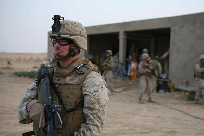Corporal Christopher J. Gudvangen, a rifleman with Jump Platoon, 3rd Battalion, 4th Marine Regiment, Regimental Combat Team 5, keeps a look out while the battalionâ??s law enforcement professional speaks to an Iraqi family in western al-Anbar Province, Iraq, Aug. 21. Marines with the Jump Platoon have been assisting the LEP in an investigation by conducting security patrols. The platoon usually escorts the battalionâ??s commanding officer, but has recently been conducting other missions like escorting the LEP.::r::::n::