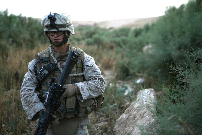 Sergeant Jay J. Richardson, a section leader with Jump Platoon, 3rd Battalion, 4th Marine Regiment, Regimental Combat Team 5, patrols through a valley to ensure no one is hiding in the brush in western al-Anbar province, Iraq, Aug. 21. The Jump Platoon is responsible for keeping the battalion commander safe during operations. Recently, the platoon has been performing alternative missions like helping the battalionâ??s law enforcement professional. Theyâ??ve provide security for the LEP while he conducts investigations.::r::::n::