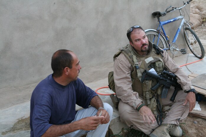 Roger Parrino, a law enforcement professional with 3rd Battalion, 4th Marine Regiment, Regimental Combat Team 5, questions an Iraqi Aug. 20 in Hit, Iraq, about an incident that occurred in the area. Parrino, 47, has used his 21 years of law enforcement experience to assist the battalion throughout their combat deployment. He has taught Marines about rule of law, detainee handling, tactical questioning, patrol observations, and sensitive-site exploitation.