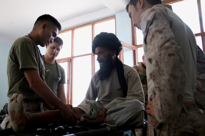Seaman Oscar Medrano, a corpsman assigned to Task Force 2d Battalion, 7th Marine Regiment, 1st Marine Division, Combined Joint Task Force Phoenix, examines the leg of an Afghan patient during a Medical Capabilities (MEDCAP) health cooperative held Aug. 24 in Delaram City, Afghanistan. (U.S. Marine Corps photo by Cpl. Steve Cushman)