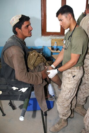 Seaman Oscar Medrano, a corpsman assigned to Task Force 2d Battalion, 7th Marine Regiment, 1st Marine Division, Combined Joint Task Force Phoenix, examines the leg of an Afghan patient during a Medical Capabilities (MEDCAP) health cooperative held Aug. 24 in Delaram, Afghanistan. (U.S. Marine Corps photo by Cpl. Steve Cushman)