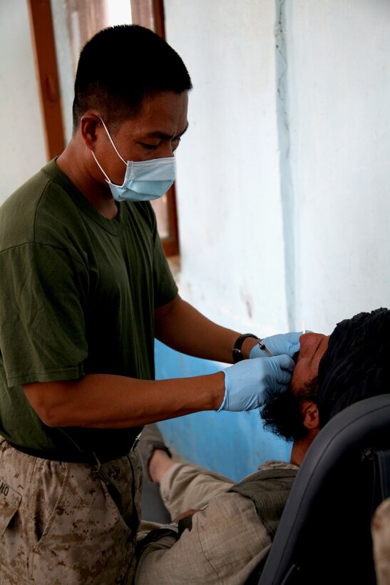 Petty Officer 2nd Class Ernesto A. Soberano, a dental hygienist assigned to Task Force 2d Battalion, 7th Marine Regiment, 1st Marine Division, Combined Joint Task Force Phoenix, performs a dental exam on an Afghan patient during a Medical Capabilities (MEDCAP) health cooperative held Aug. 24 in Delaram. (U.S. Marine Corps photo by Cpl. Steve Cushman)