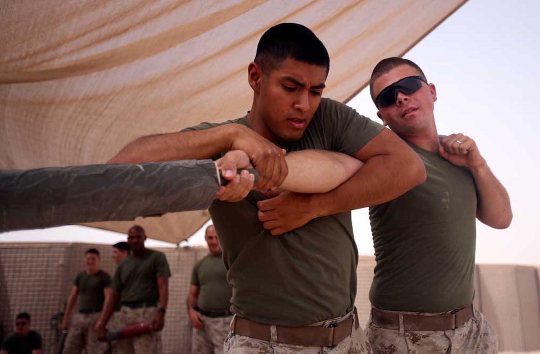 Cpl. Michael Gutierrez, a motor transport operator with Marine Unmanned Aerial Vehicle Squadron 2, Marine Aircraft Group 16, 3rd Marine Aircraft Wing (Forward), executes a counter attack on Cpl. Michael Worthington, an armorer with the squadron. Gutierrez performed the move while Worthington simulated attacking him with a stick. Readily available items such as sticks or rocks are referred to as weapons of opportunity. Worthington and Gutierrez earned their brown belts during their deployment.