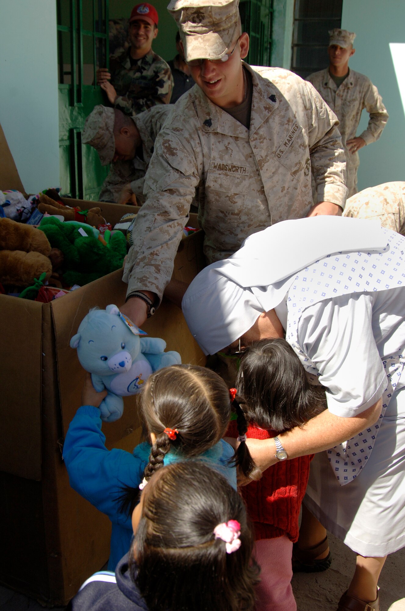 U.S. Marine Sgt. Danial Wadsworth, a vehicle maintainer with Task Force New Horizons, gives a toy to a Peruvian girl at the Juan Andres Vivanco Amorin Orphanage in Ayacucho, Peru, Aug. 14.  Task froce members visited the orphanage to bring toys collected by the 472nd Marine Wing Support Squadron at Willow Grove, Pa., and to spend the morning playing with the children.  More than 950 servicemembers deployed to Ayacucho, Peru to support New Horizons - Peru 2008, a U.S. and Peruvian humanitarian effort to bring quality-of-life construction projects and medical missions to impoverished Peruvians. (U.S. Air Force photo/1st Lt. Mary Pekas)