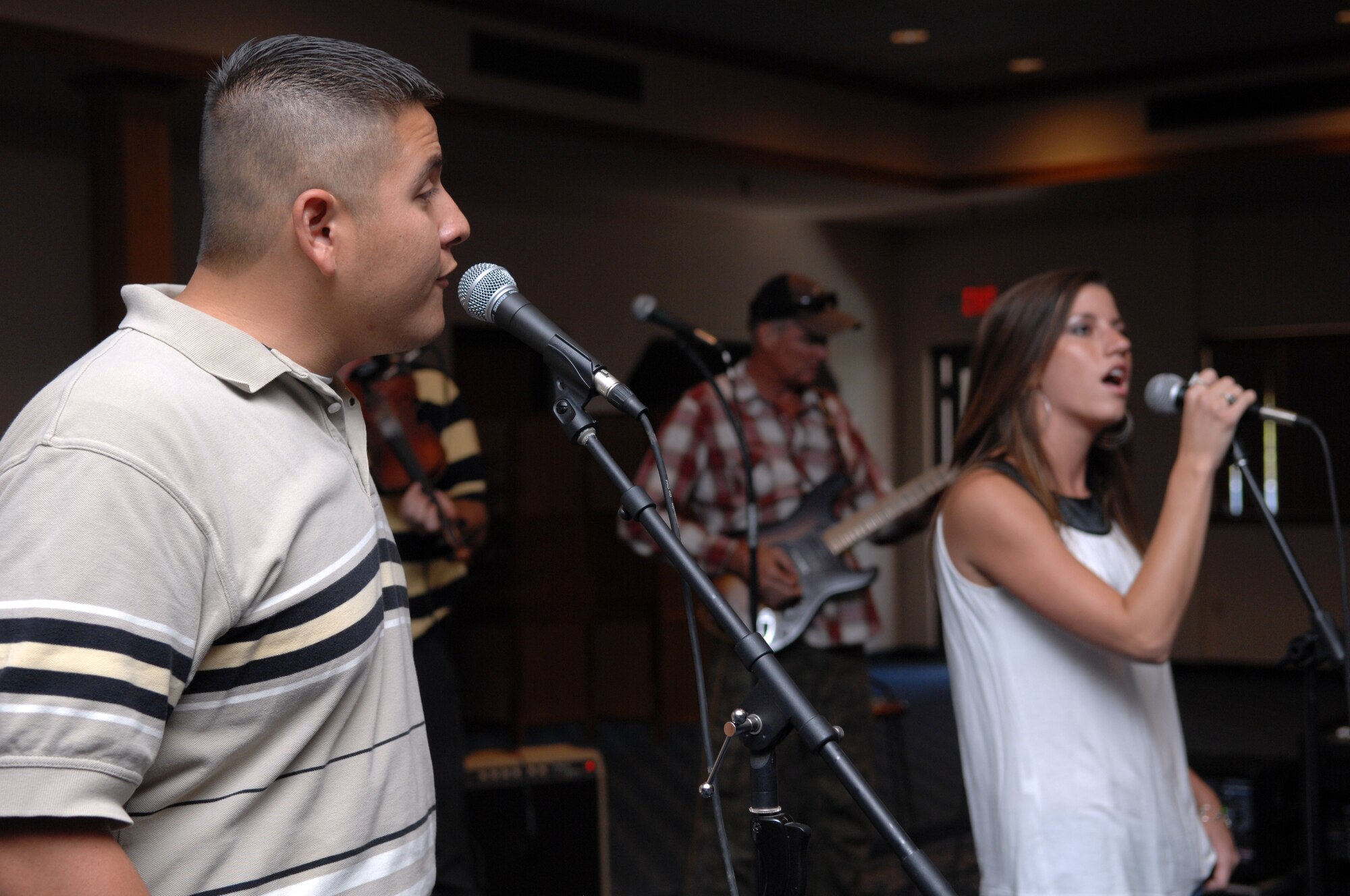A band sponsored by Desert Sands Motors of Alamogordo, performed live entertainment during the Big Give After Party at the Enlisted Club at Holloman Air Force Base, N.M., August 21. The after party also offered many appetizers and drinks for people as they checked out presentations of different teams. At the end of the party, everyone voted, and the winning team, Housebusters, was announced. (U.S. Air Force photo/Airman Sondra M. Wieseler)