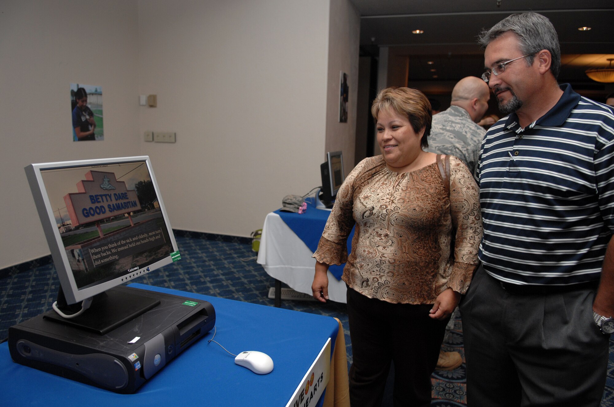 Josie Cole and Blaine Jackson, both from the civilian personnel office, check out one of the many Big Give teams? presentations which were set up around the Enlisted Club during the Big Give After Party at Holloman Air Force Base, N.M., August 21. Each team presented what they did to help the city of Alamogordo, many through computer presentations and some through photo books. Everyone who attended the after party had the opportunity to look at what each team did before voting for their favorite team. (U.S. Air Force photo/Airman Sondra M. Wieseler)
