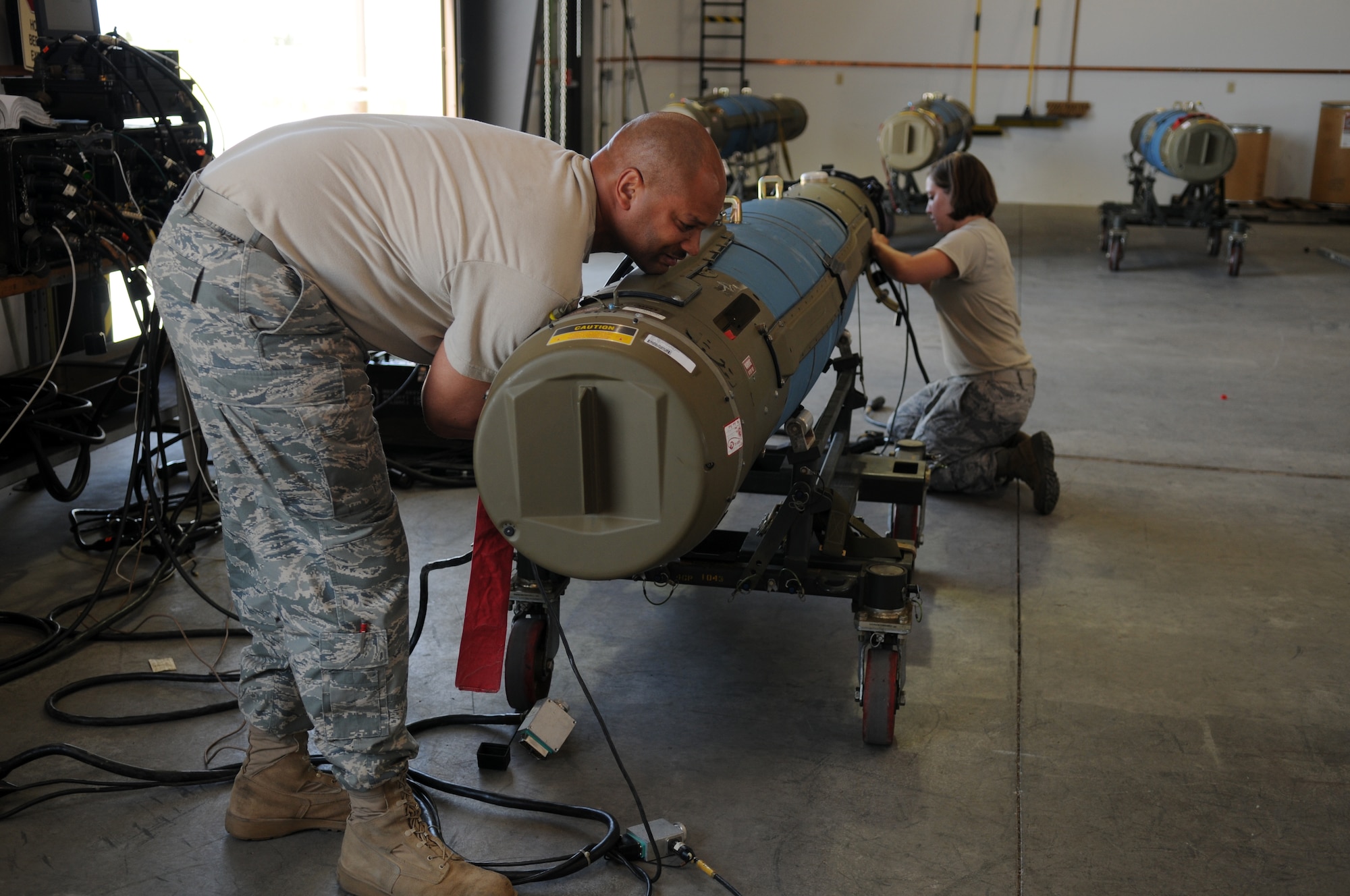Technical Sgt. Ray Pipkins, precision guided munitions production superintendent for the 4th Equipment Maintenance Squadron at Seymour Johnson Air Force Base, works with Senior Airman Keegan Vanderpoel here July 30 to prepare a bomb for the Air Force air-to-ground Weapons System Evaluation Program known as Combat Hammer.  Airmen and aircraft from 10 Air Combat Command units participated in the Aug. 4-22 program and dropped over $1.2 million-worth of munitions. With support from the 388th Range Squadron, Airmen in Eglin AFB's 86th Fighter Weapons Squadron, 53rd Wing, will collect and analyze data on how these precision weapons performed and their suitability for use in War on Terror deployments. (U.S. Air Force photo by James Arrowood)     