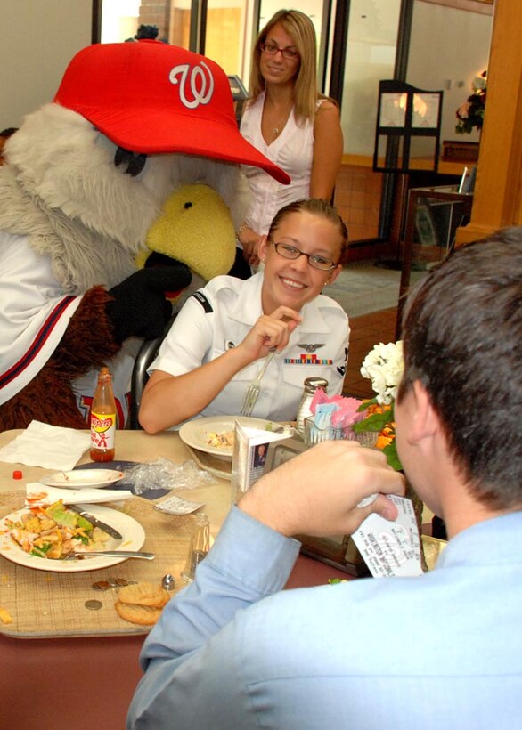 The Washington D.C. Nationals baseball team mascot Screech teases Petty Officer 2nd Class Nicole Tsystuck of the Naval Ice Center, Suitland, Md., at the Freedom Hall Dining Facility Aug. 25. Screech handed out free tickets to servicemembers for the Nationals' game against the Braves Friday.