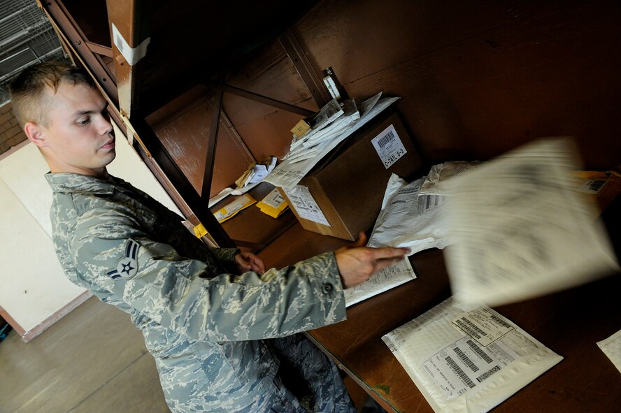 MOODY AIR FORCE BASE, Ga. -- Airman 1st Class David Definbaugh, 23rd Logistics Readiness Squadron vehicle operator, sorts through packages to scan into the system before delivery here Aug. 7. The LRS pick-up and delivery flight will soon be merging with the traffic management office to reduce commodity hand-offs between multiple offices. (U.S. Air Force photo by Senior Airman Brittany Barker)