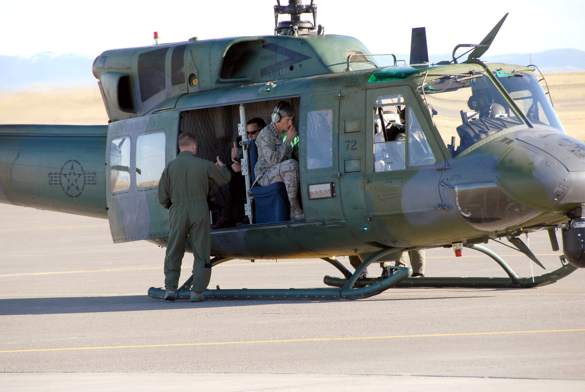 Air Force Chief of Staff Gen. Norton A. Schwartz observes the pre-flight maneuvers of Capt. Ryan Dahlin, 40th Helicopter Squadron aircraft commander, while Special Agent Randy Metzger gives flight engineer Staff Sgt. Mike France a thumbs up.  The UH-1N Huey transported the distinguished visitors to missile alert facility Bravo-01 Aug. 22 during their visit to Malmstrom Air Force Base, Mont. (U.S. Air Force photo/John Turner)