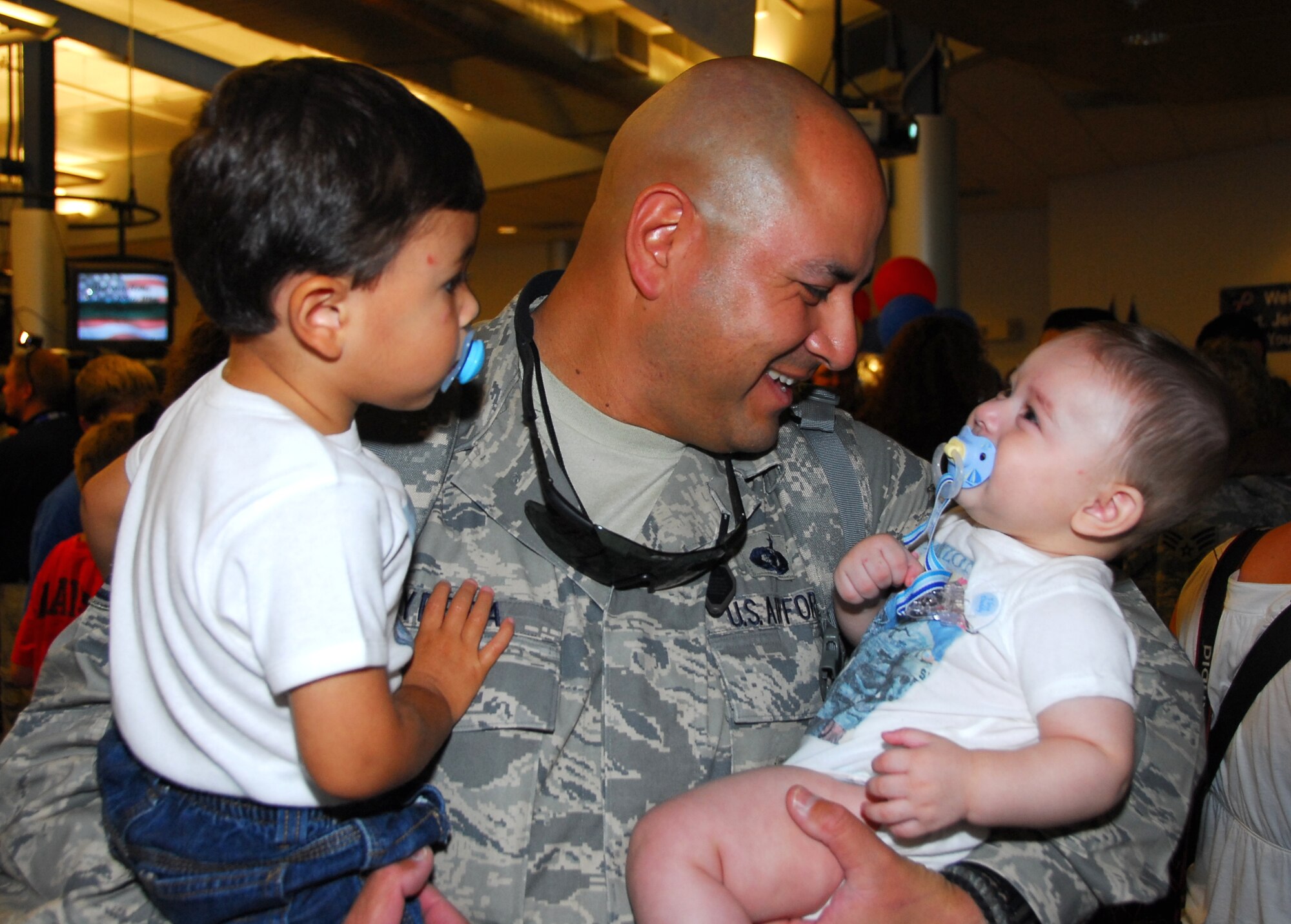 Staff Sgt. Juan Yebra holds his son Andres and his new grandson Henry. All 19 of the 162nd Fighter Wing’s Security Forces members returned home safely Aug. 23 after six months in Iraq. (Air National Guard photo by Master Sgt. Dave Neve)