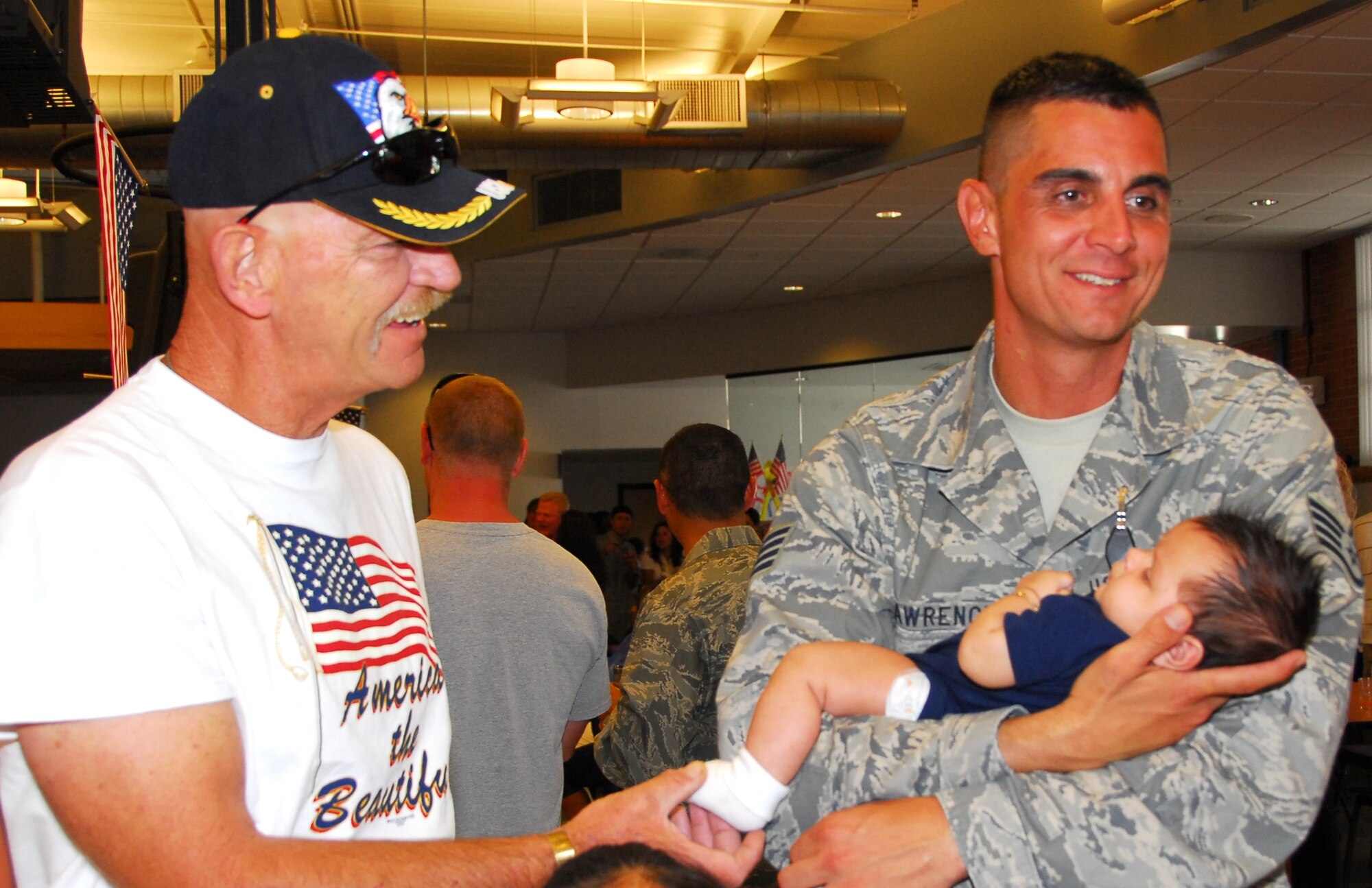 Staff Sgt. Dan Lawrence meets his son Ryan for the first time while his father Chief Master Sgt. (Ret.) Dan Lawrence looks on. All 19 of the wing’s Security Forces members returned home safely Aug. 23 after six months in Iraq. (Air National Guard photo by Master Sgt. Dave Neve)