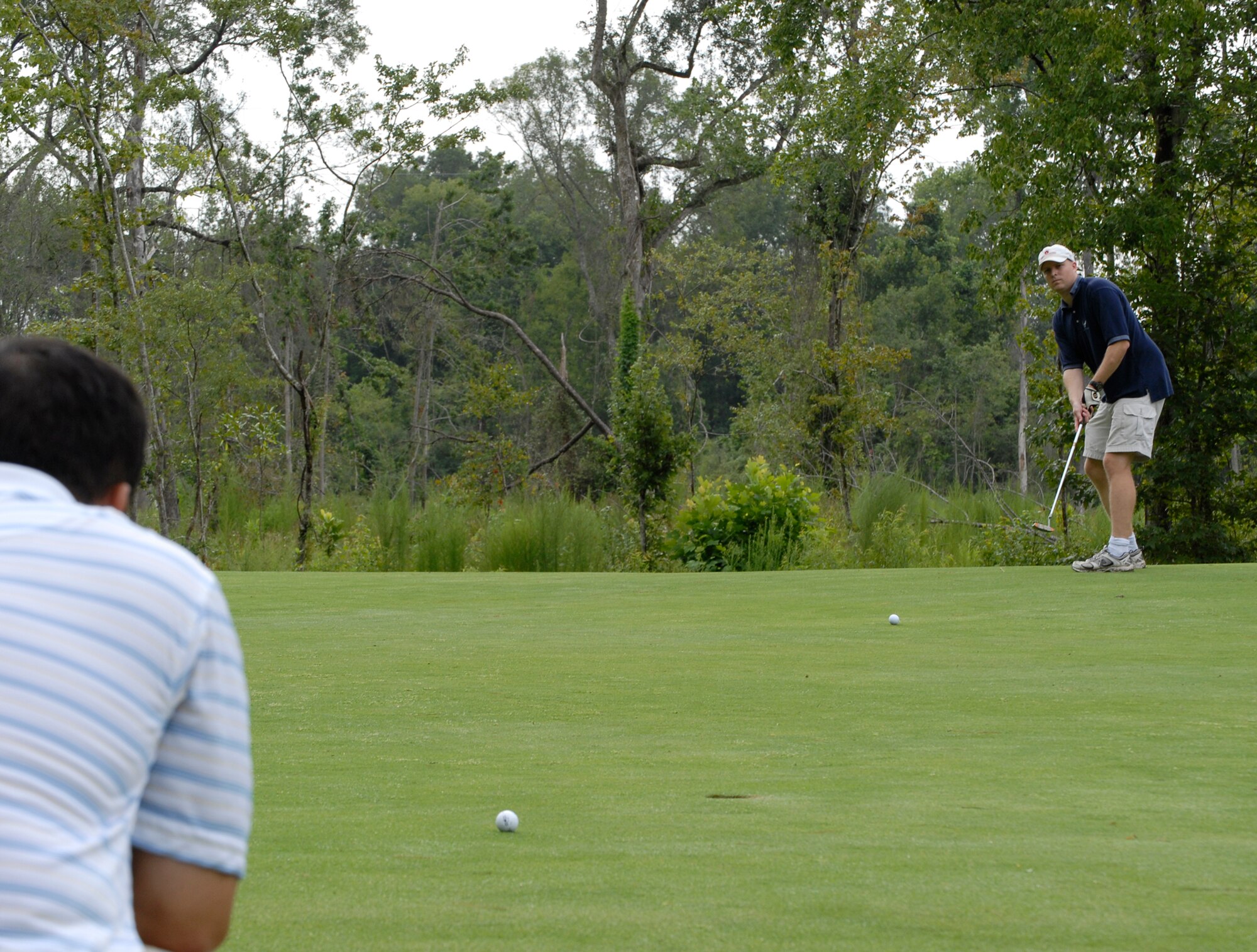 Master Sgt. Francisco Endaya watches the birdie putt of Capt. Jeff Bartlett ties on the first hole during the Air Force Ball golf tournament at Miller Golf Club in Summerville, S.C., Aug. 22. The tournament was held to raise money for the annual ball to be held Sept. 6. Tickets are still available at the 437th Airlift Wing protocol office for $35 a person. For more information call protocol at 963-8002. Sergeant Endaya and Captain Bartlett are assigned to the 437th Airlift Wing Safety Office. (U.S. Air Force photo/Master Sgt. Sean Houlihan)