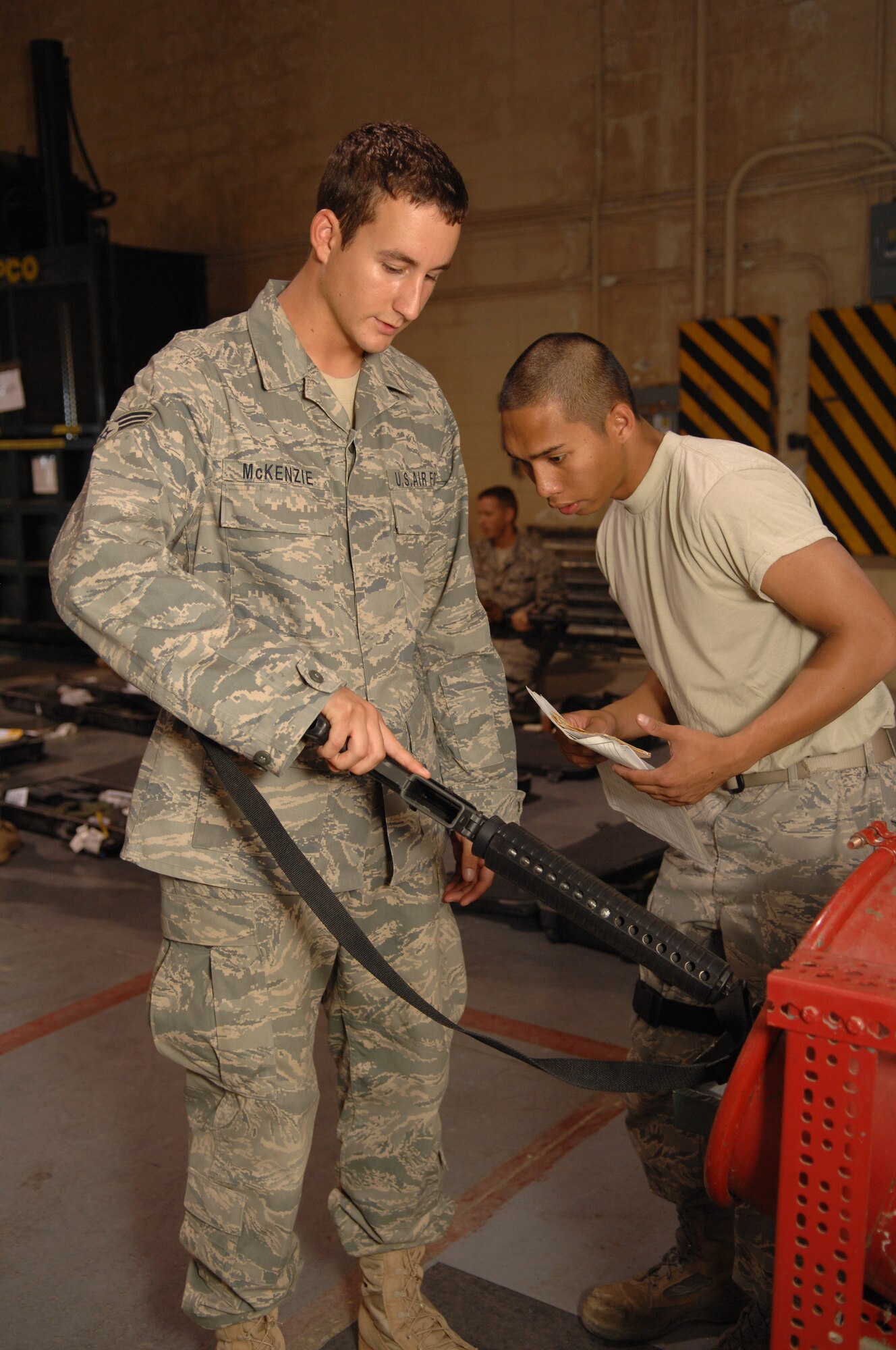 Senior Airman John McKenzie, 49th Materiel Maintenance Squadron, clears his weapon with the assistance of Airman 1st Class Emerson Ackley, 49th Logistics Readiness Squadron,  at Holloman Air Force Base, N.M., August 20. Airmen McKenzie handed in his weapon after returning from a 74-day deployment to Southwest Asia. (U.S. Air Force photo/Airman Sondra M. Wieseler)