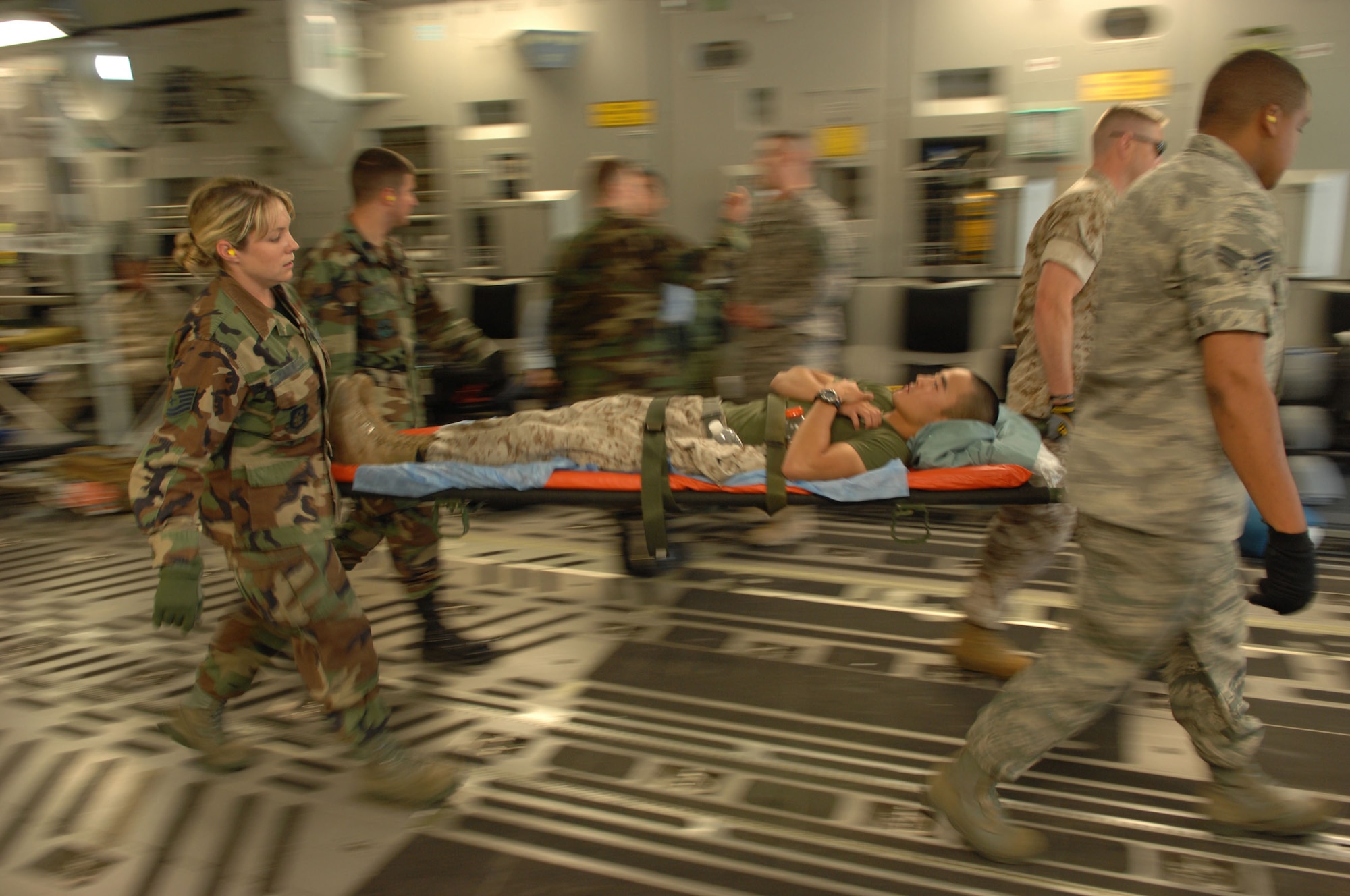 Tech. Sgt. Shea Harkness, left, a reservist from the 710th Medical Squadron, Offutt Air Force Base, Nebraska, helps carry a wounded Marine from onboard a C-17 Globemaster at Ramstein Air Base Germany July 27.  The 710th is a geographically-seperated unit in the 442nd Fighter Wing, an Air Force Reserve unit based at Whiteman Air Force Base, Mo. (U.S. Air Force photo by Senior Airman Amber Bressler)