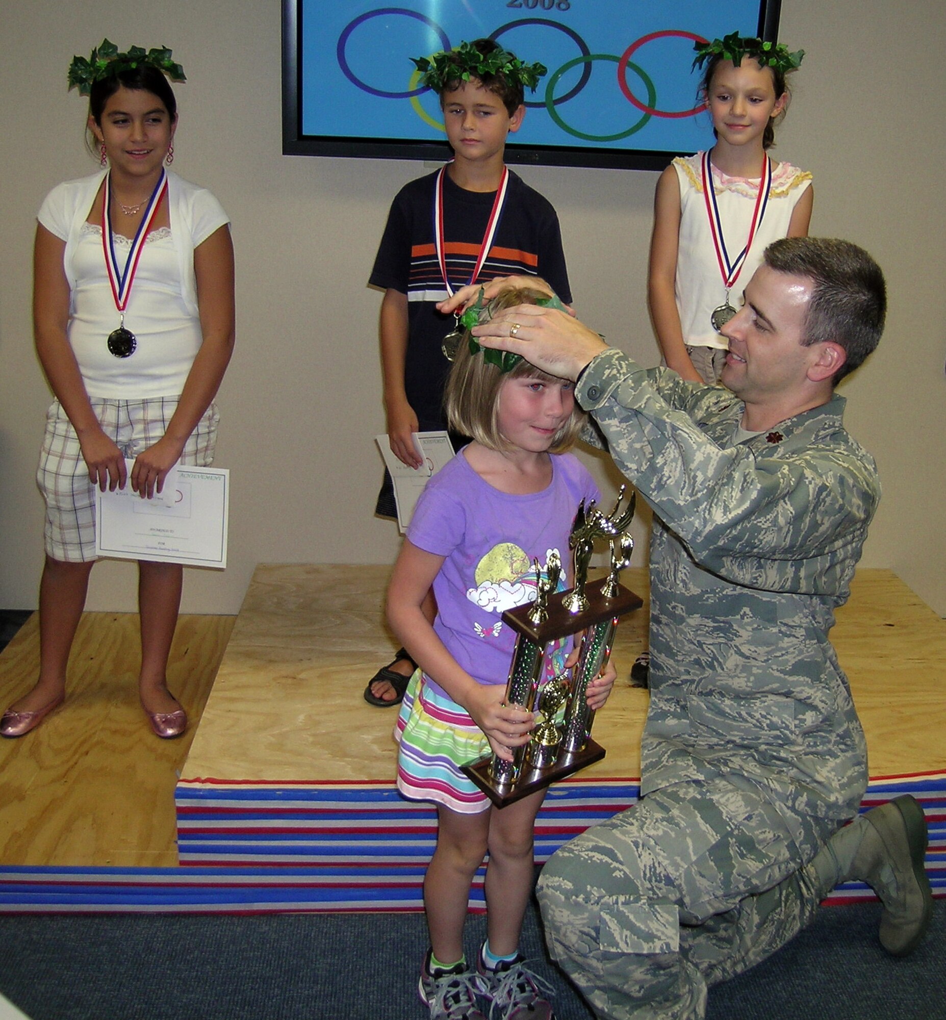 Maj. Paul Johnston, 71st Force Support Squadron commander, presents a halo to Brooke Tiedt, the Summer Reading program grand prize winner, Aug. 9, at the Vance Library. Behind them, from left, are second place winner, Sara Tapia, and first place winners, Nicholas Lostetter and Kate Nash. Brooke read 218 books between June 2 and July 31 to earn the grand prize. More than 26 youth participated in this year’s program. (Photo by Tech. Sgt. Richard White)