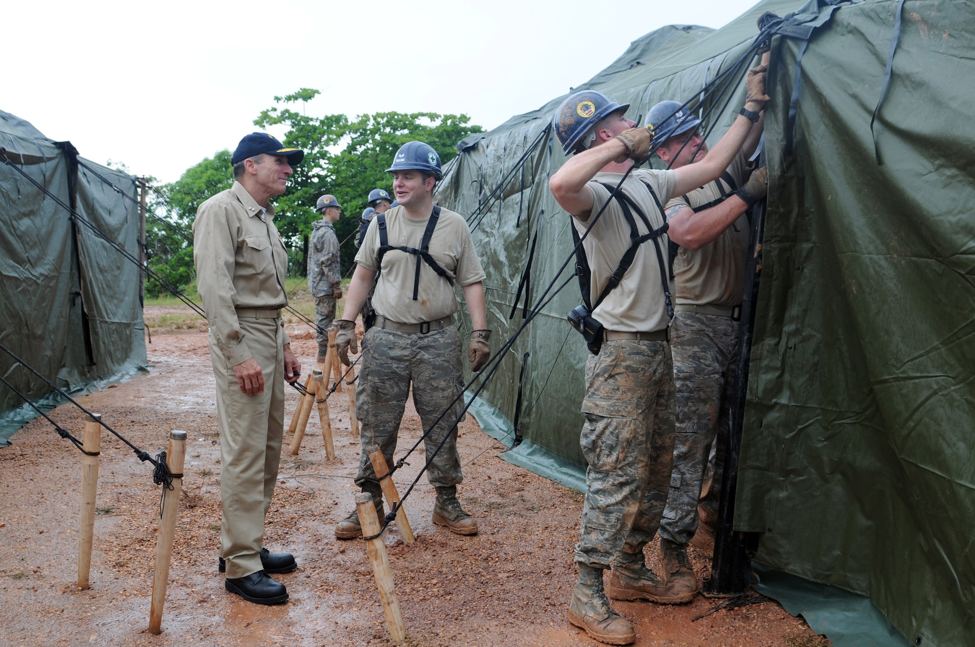 PUERTO CABEZAS, Nicaragua -- Rear Adm. Joseph Kernan, commander of the U.S. 4th Fleet, speaks with Senior Airman Joshua Mann, 5th Civil Engineer Squadron electrical systems journeyman, while Staff Sgt. John Kimble, 5th CES utilities systems journeyman, and Staff Sgt. Jeremy Thomas, 5th CES pavement and equipment craftsman, finish tightening support ropes on a tent. The crew is part of the 5th CES team providing engineering assistance to the people of Nicaragua as part of Continuing Promise 2008. Continuing Promise 2008 is an equal-partnership mission between the United States, Canada, the Netherlands, Brazil, Nicaragua, Panama, Colombia, Dominican Republic, Trinidad and Tobago and Guyana. (U.S. Navy photo by Mass Communication Specialist Third Class William S. Parker)